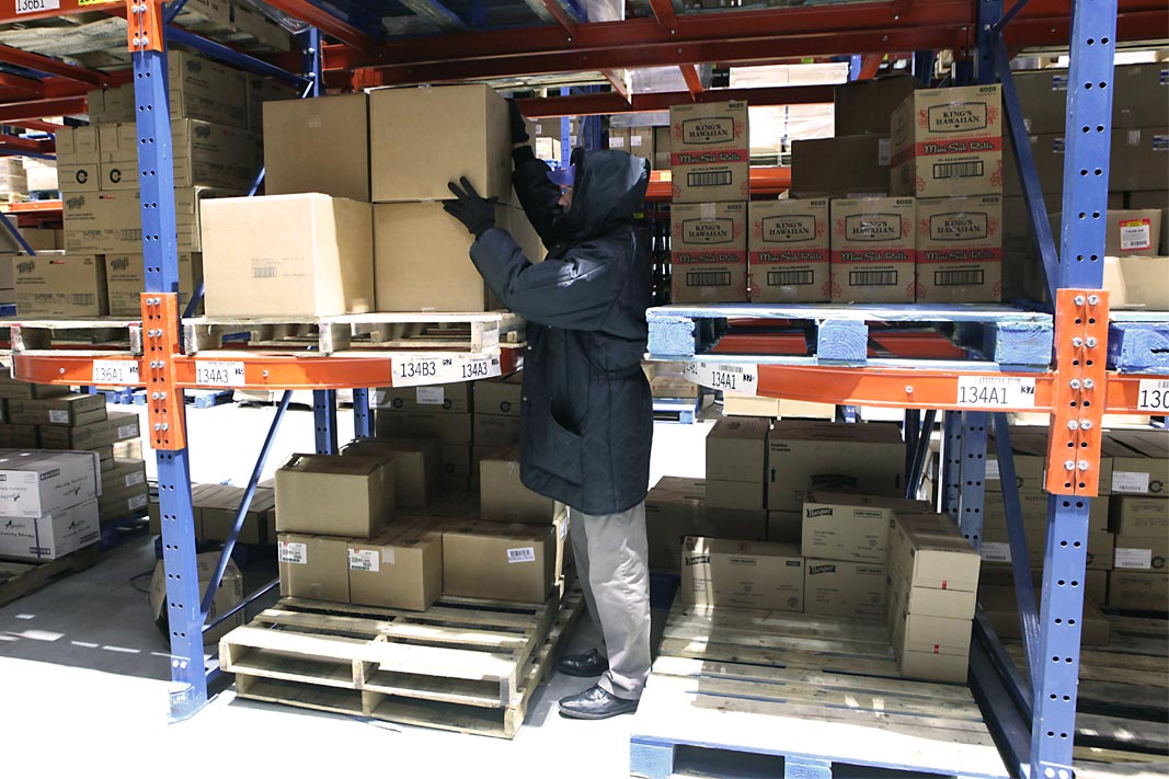 A worker picks a case from Ergo-Label Beam® pallet racking.
